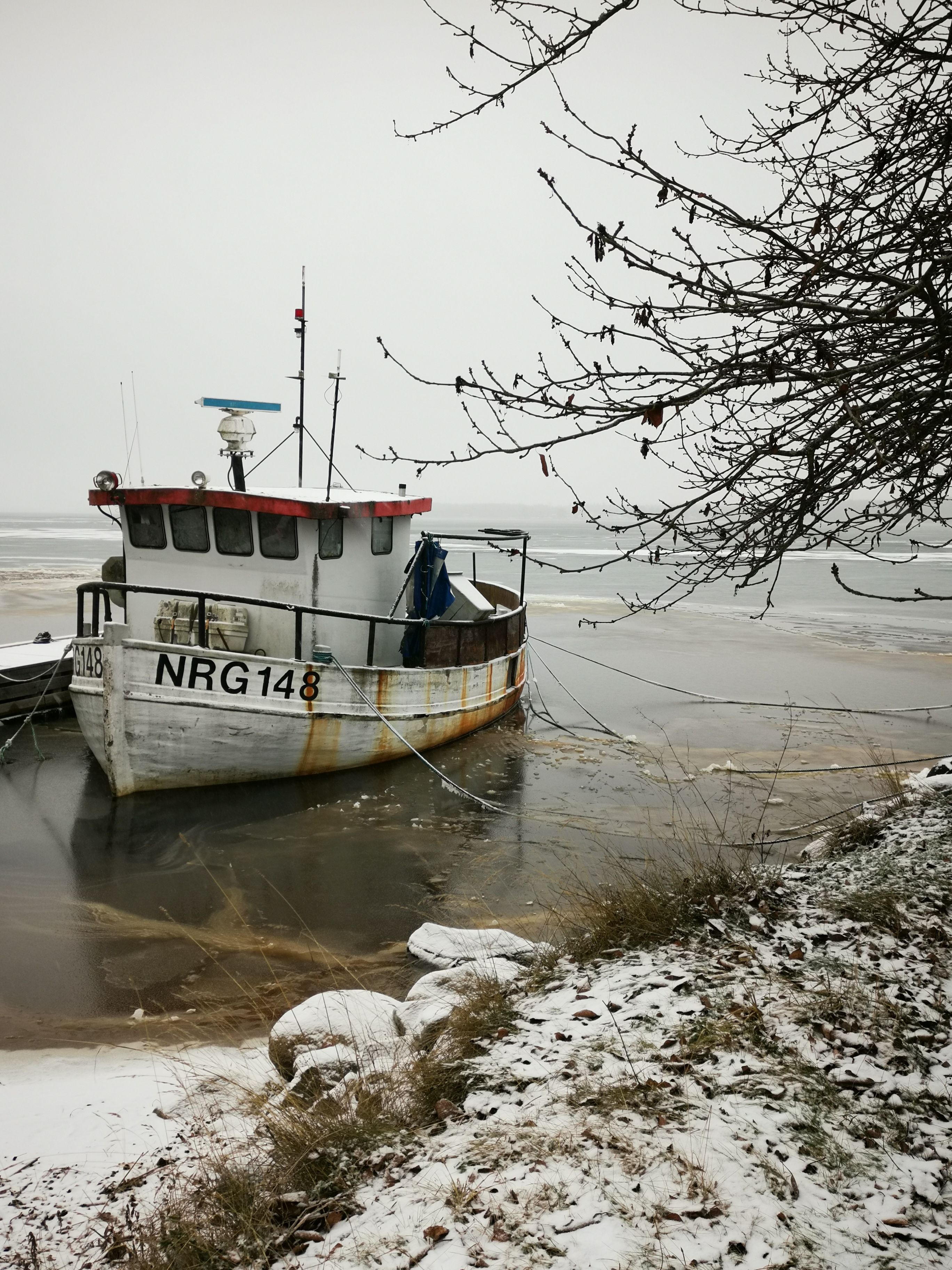 An Old White Boat Perched on the Side of the River · Free Stock Photo