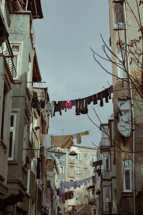 Free Clothes drying on lines between apartment buildings in a vintage city alleyway. Stock Photo