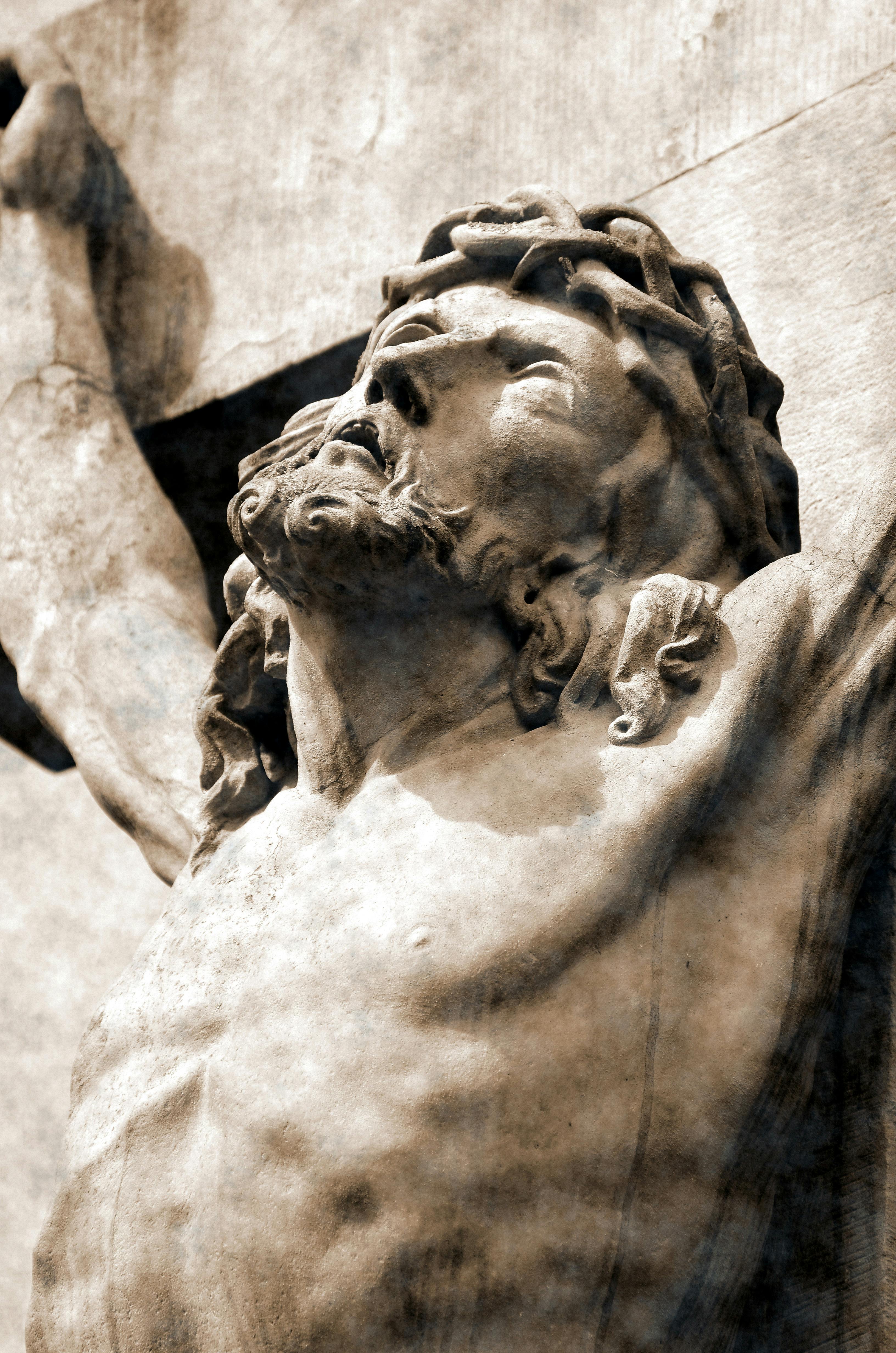 Close-up of a detailed stone sculpture depicting Jesus Christ with an expressive look.