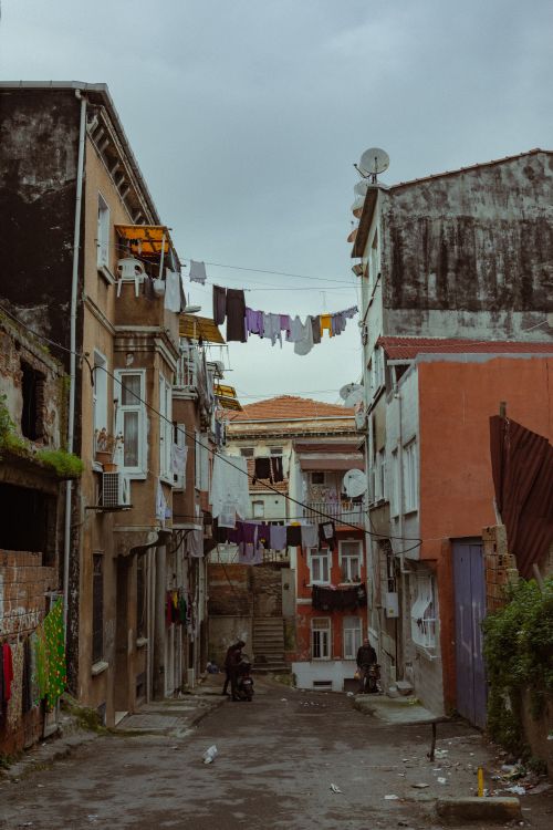 Free Gloomy street scene with clotheslines and aging houses, capturing urban life. Stock Photo