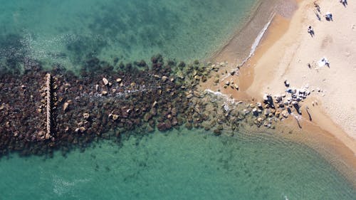 Aerial Footage of Stones, Sand and Turquoise Ocean