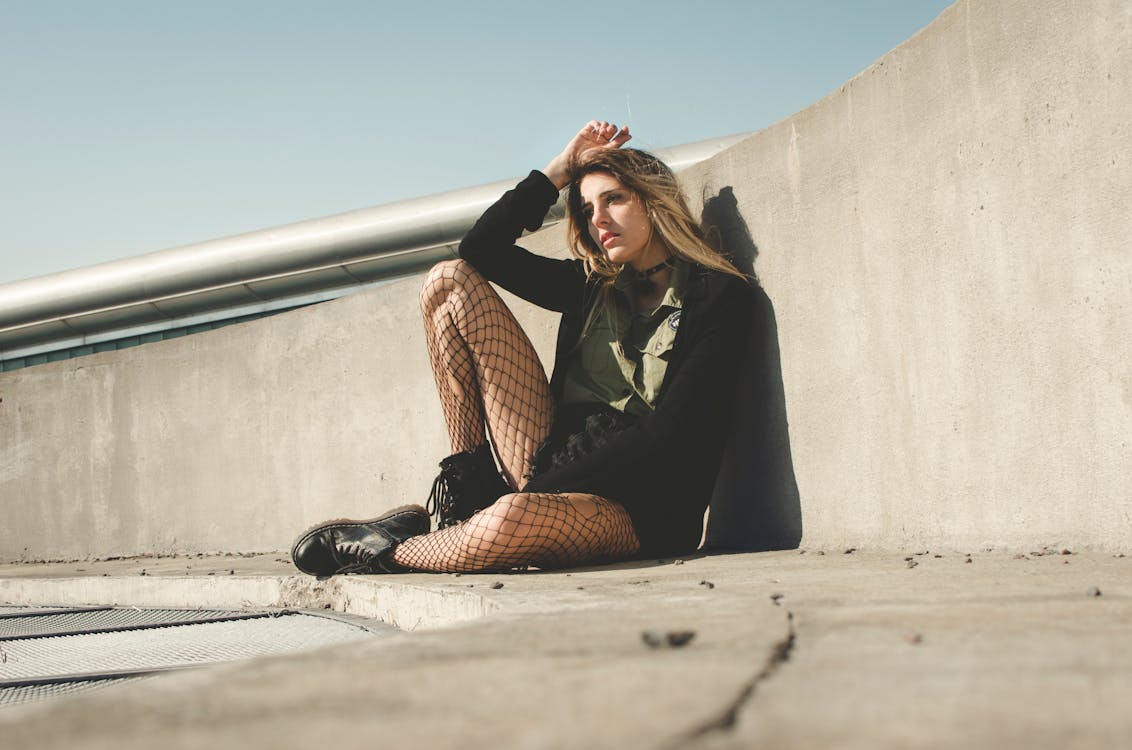 Photography of a Woman Leaning on a Wall