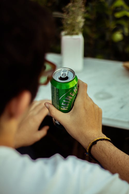 Close Up Photo of Person Holding a Can