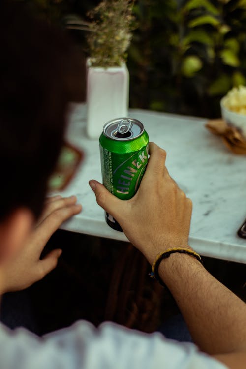 Person Holding a Can in Close Up Photography