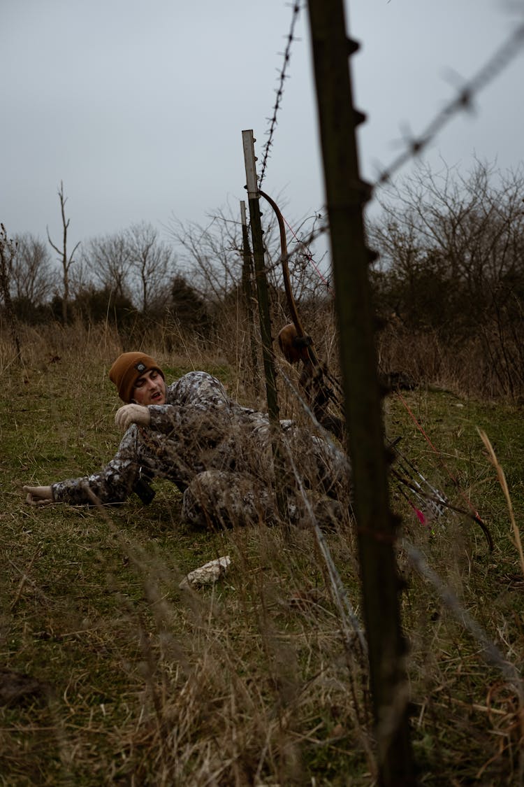 Man Crawling Under A Wire Fence