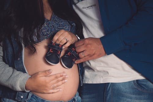 A Couple Holding Baby Shoes 