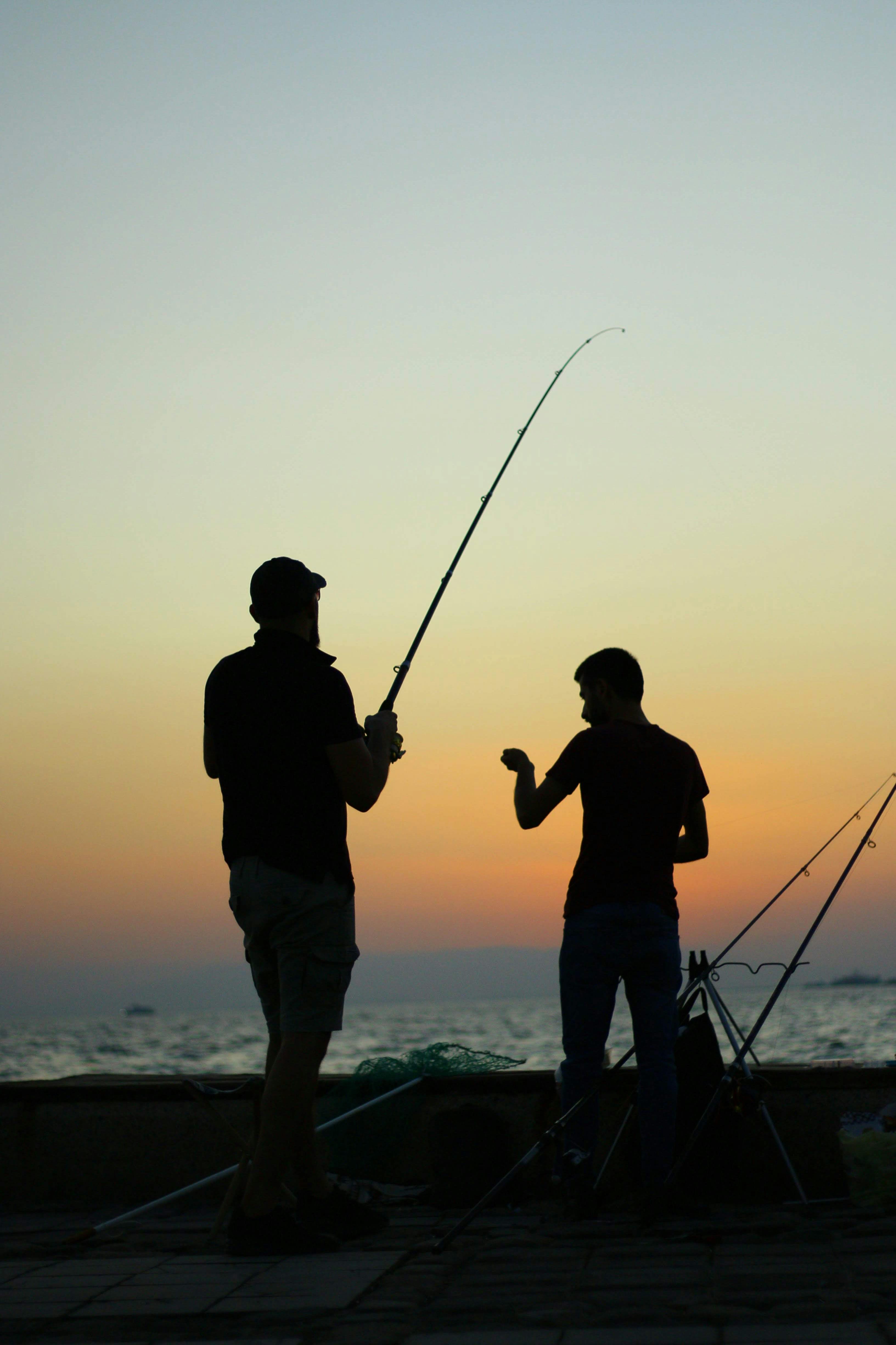 Silhouette of Two Men Fishing During Sunset · Free Stock Photo