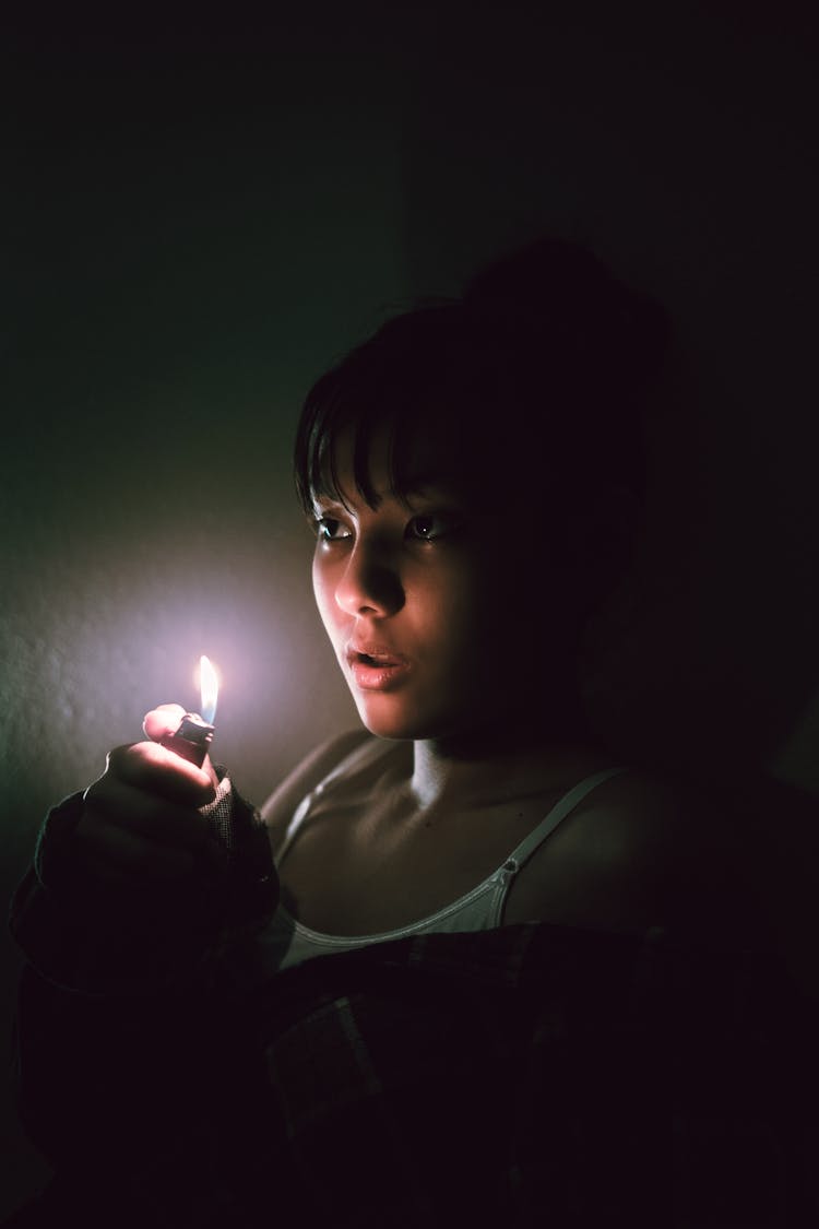 Woman In White Tank Top Holding A Lighter