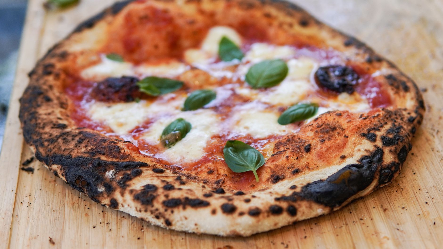 Closeup of Margherita pizza slice with melted cheese and basil