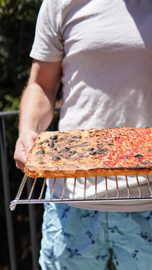 Free Person holding a Pizza on a Metal Tray Stock Photo