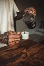Person Pouring Black Liquid on White Ceramic Mug