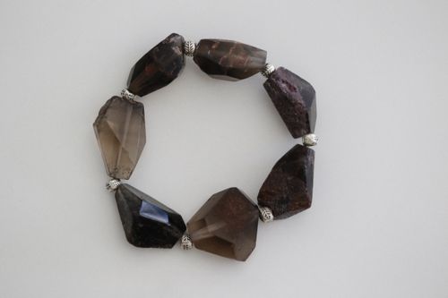 Free Close-up of a handmade gemstone bracelet featuring dark stones on a white surface. Stock Photo