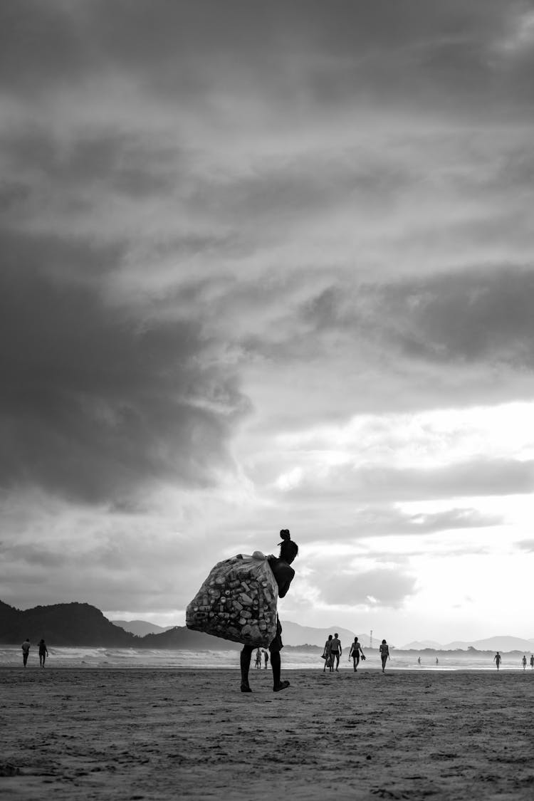 Man Carrying A Trash Bag On A Beach