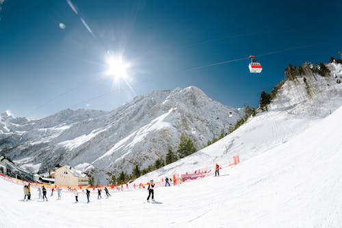 View of People Skiing on a Slope under a Clear Blue Sky 