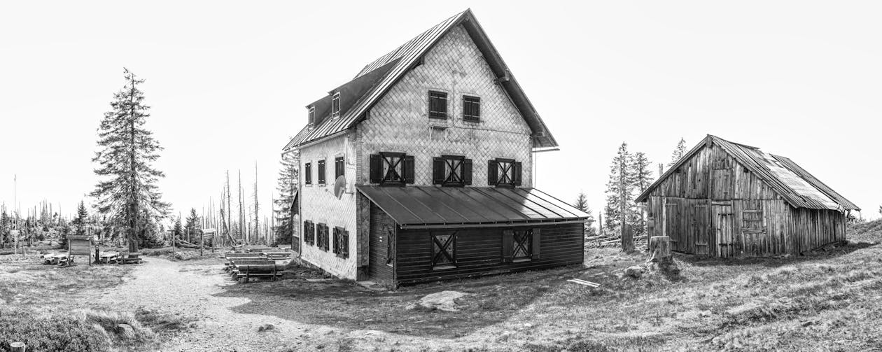 Grayscale Photography of 3-storey House Near Shack Digital Wallpaper