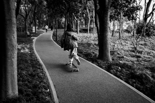 Grayscale Photo of Person Using Skateboard on Park 