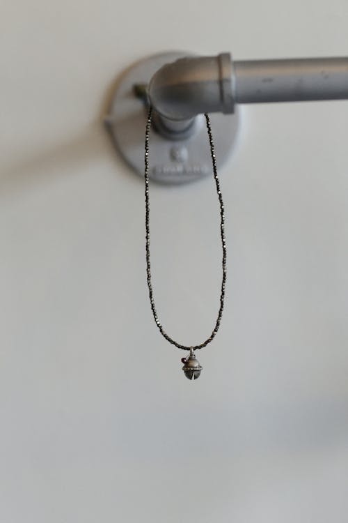 Бесплатное стоковое фото с вертикальный выстрел, висячий, ожерелье
