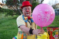 Smiling Man in White and Blue Polo Shirt Holding Pink Balloons