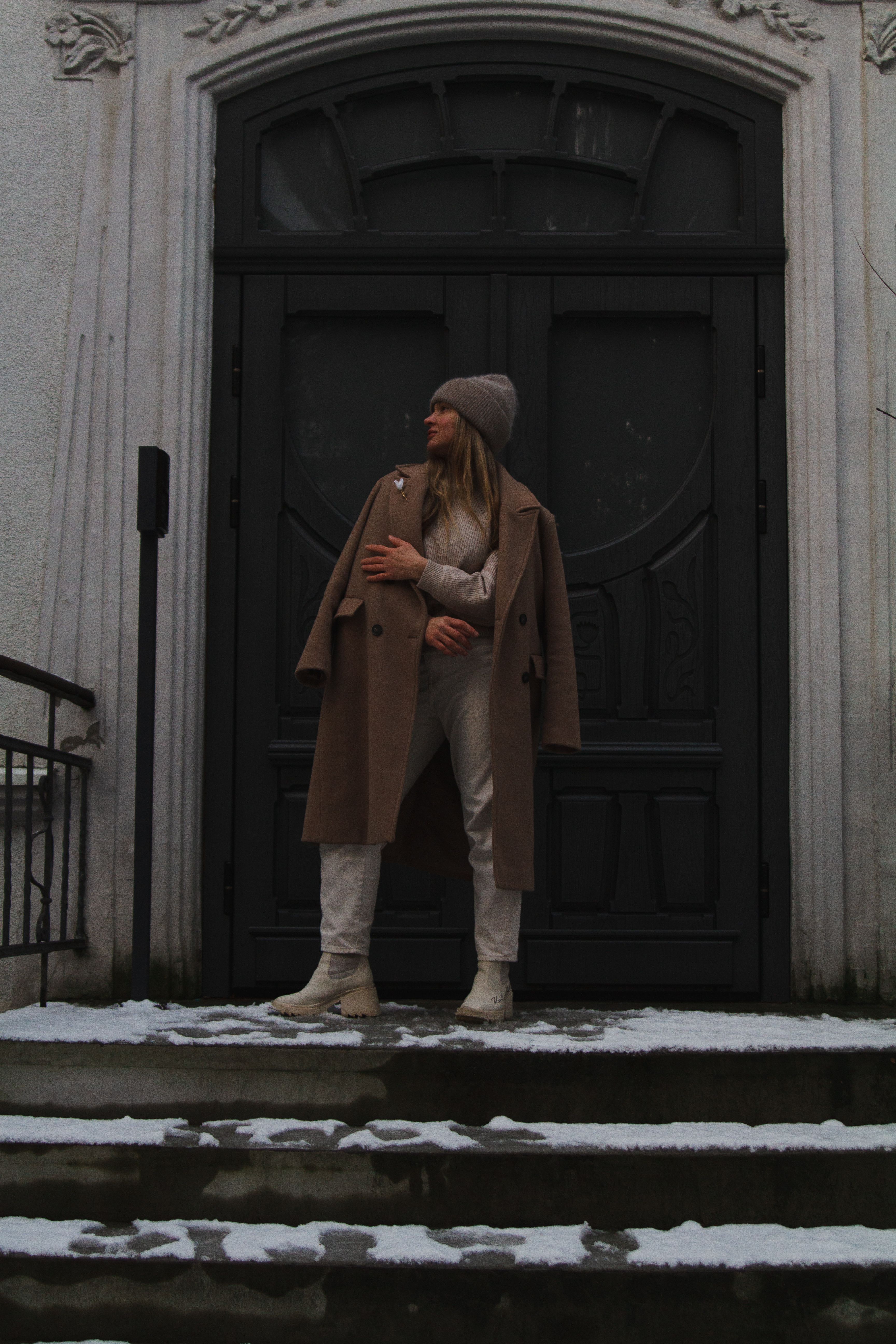 Woman in Brown Coat Standing in Front of Door · Free Stock Photo