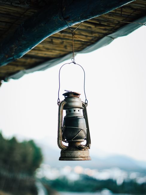 Vintage hanging lantern with scenic Moroccan background, showcasing rustic charm.