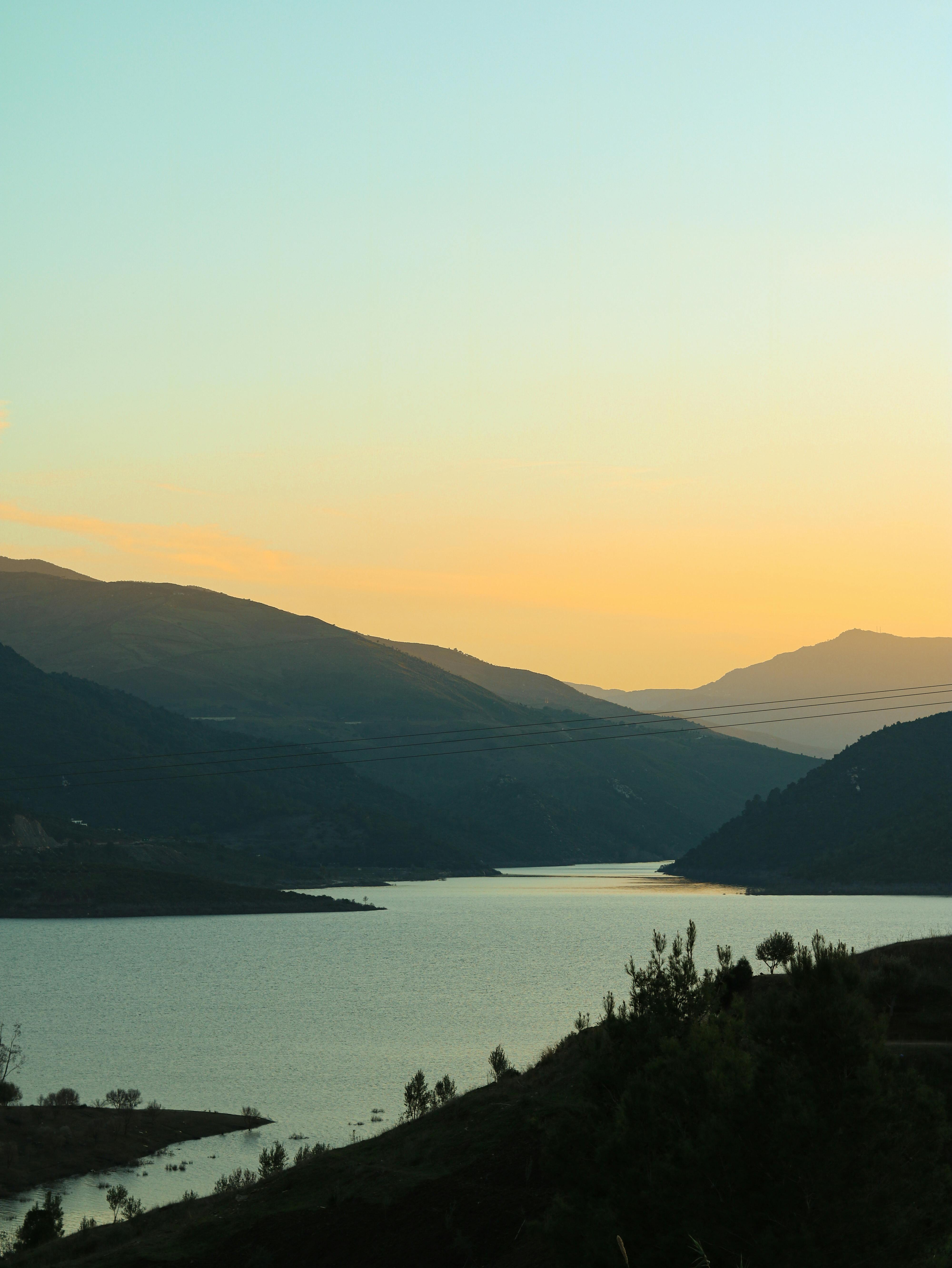 Captivating sunset view over a tranquil body of water surrounded by Moroccan mountains.