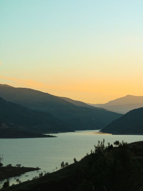 Captivating sunset view over a tranquil body of water surrounded by Moroccan mountains.
