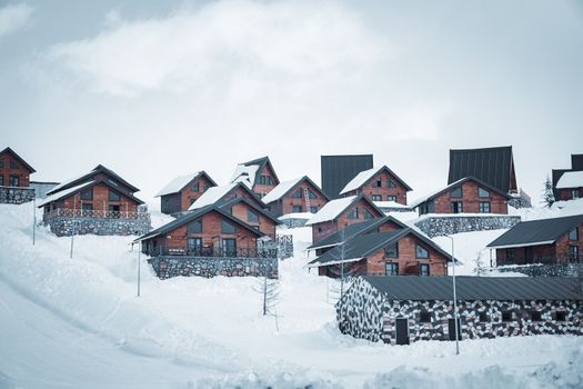 Charming wooden cabins on a snowy hill in Kahramanmaraş, Türkiye during wintertime.