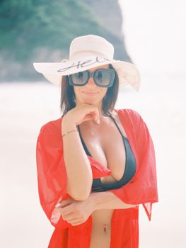Elegant woman in beachwear enjoying a sunny day on a Bali beach, exuding summer vibes.