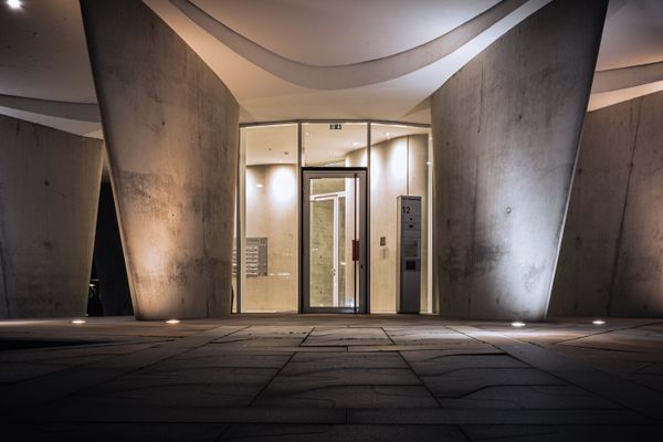 Curved concrete entrance hall at night — photo by Niklas Jeromin on Pexels