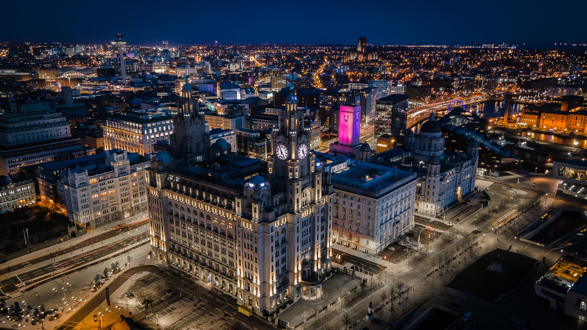 Stunning aerial image of Liverpool's skyline at night showcasing iconic buildings and city lights.
