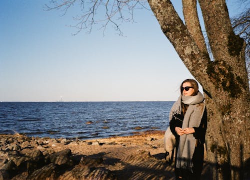 Woman in White Hijab Standing Beside Tree Near Sea