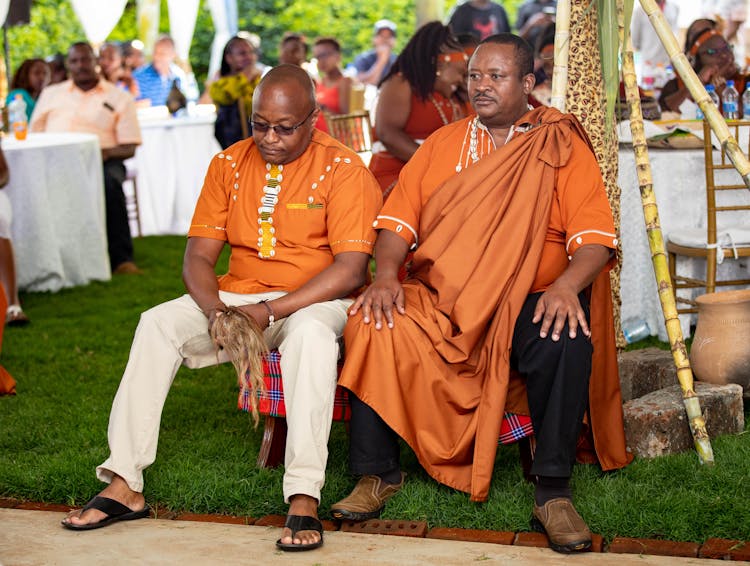 Men Sitting Wearing Orange Shirts 