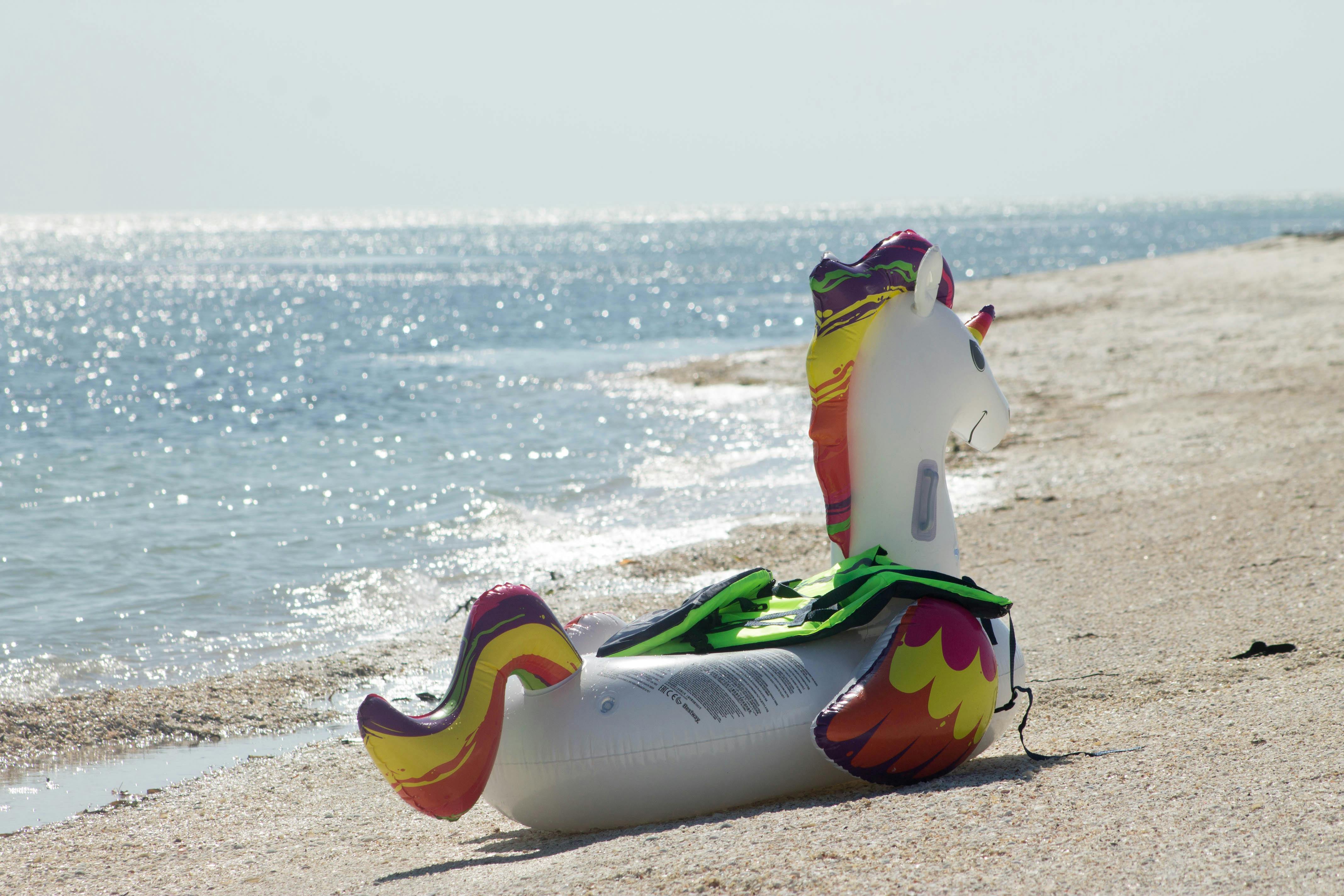 Vibrant unicorn inflatable on sunny Isla Aguada beach in Mexico, perfect for a summer escape.
