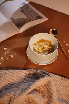 Warm soup with an open book, cozy indoor ambiance, perfect for relaxation.