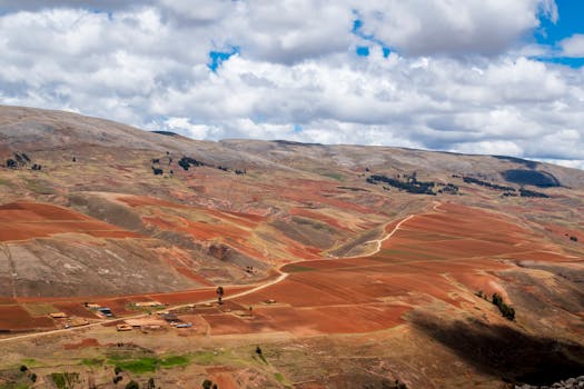 Stunning view of the red-brown hills and scattered clouds over the Andes in Junín, Peru.