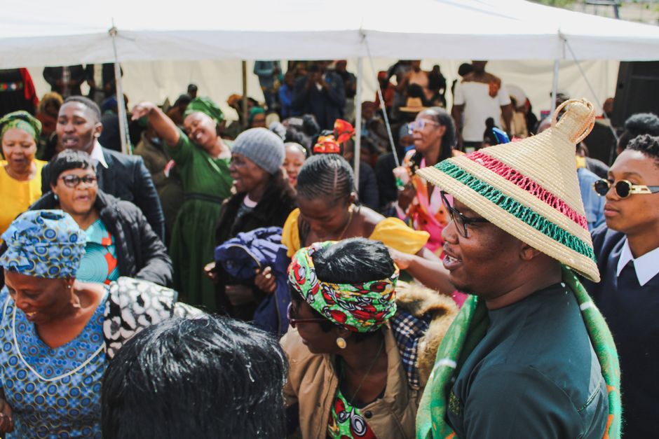 Colorful outdoor festival scene in South Africa with joyful crowd celebrating.