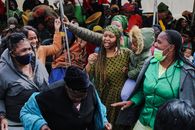 Vibrant street gathering in South Africa with women celebrating energetically.