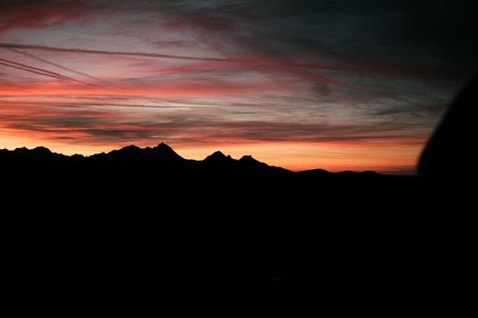Captivating silhouette of a mountain range under a vibrant sunset sky in Germany.