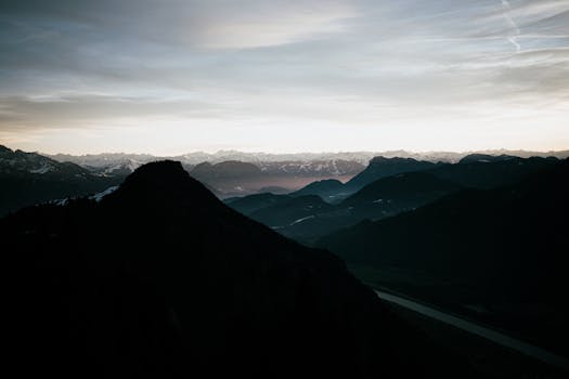 Captivating twilight view of mountainous silhouettes under a vast, dramatic sky in Germany.