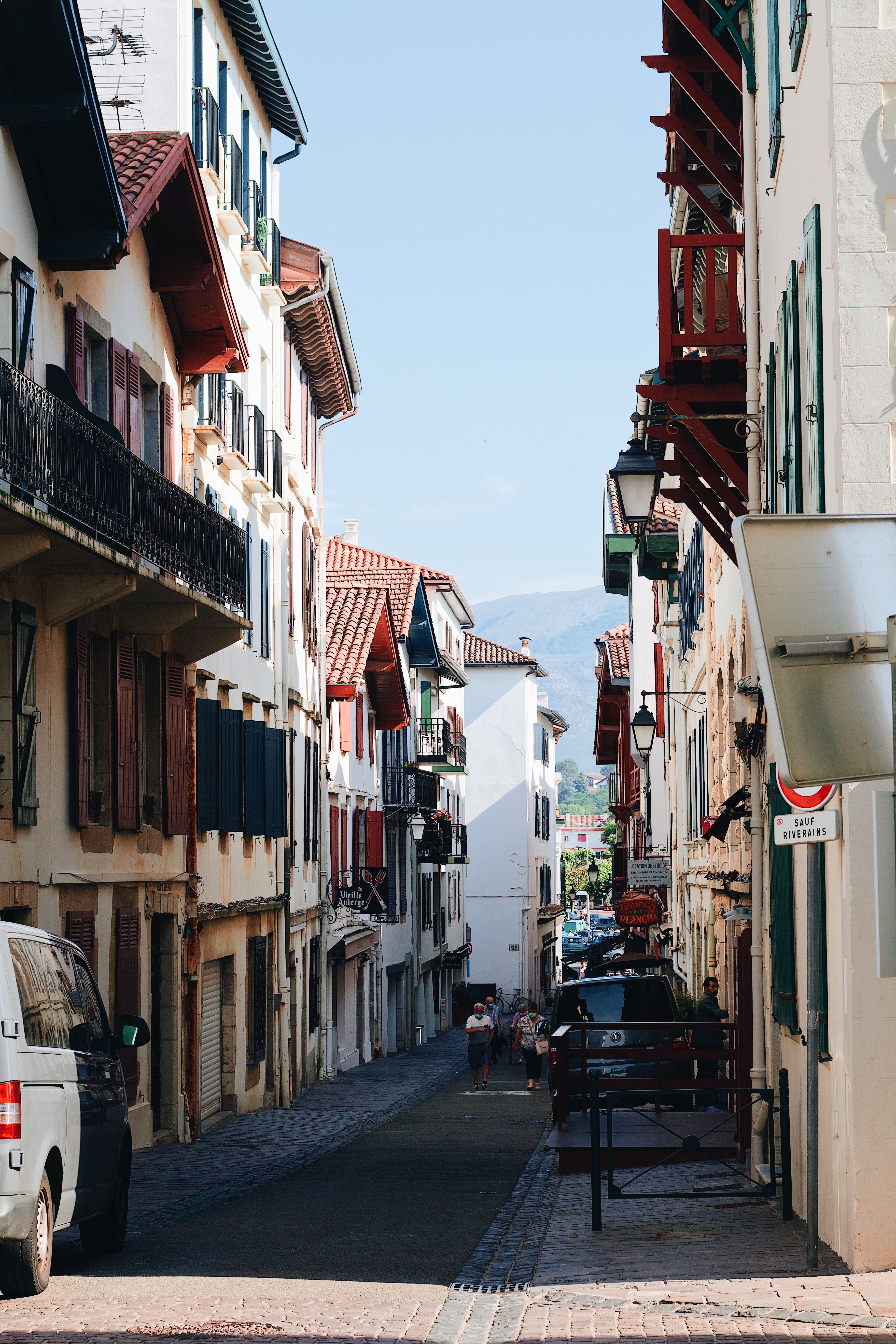 Discover the charm of a narrow street flanked by traditional European buildings under a clear sky.