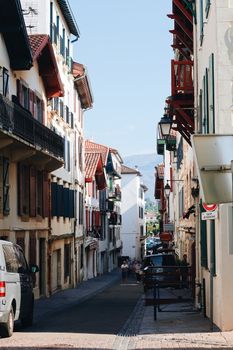 Discover the charm of a narrow street flanked by traditional European buildings under a clear sky.