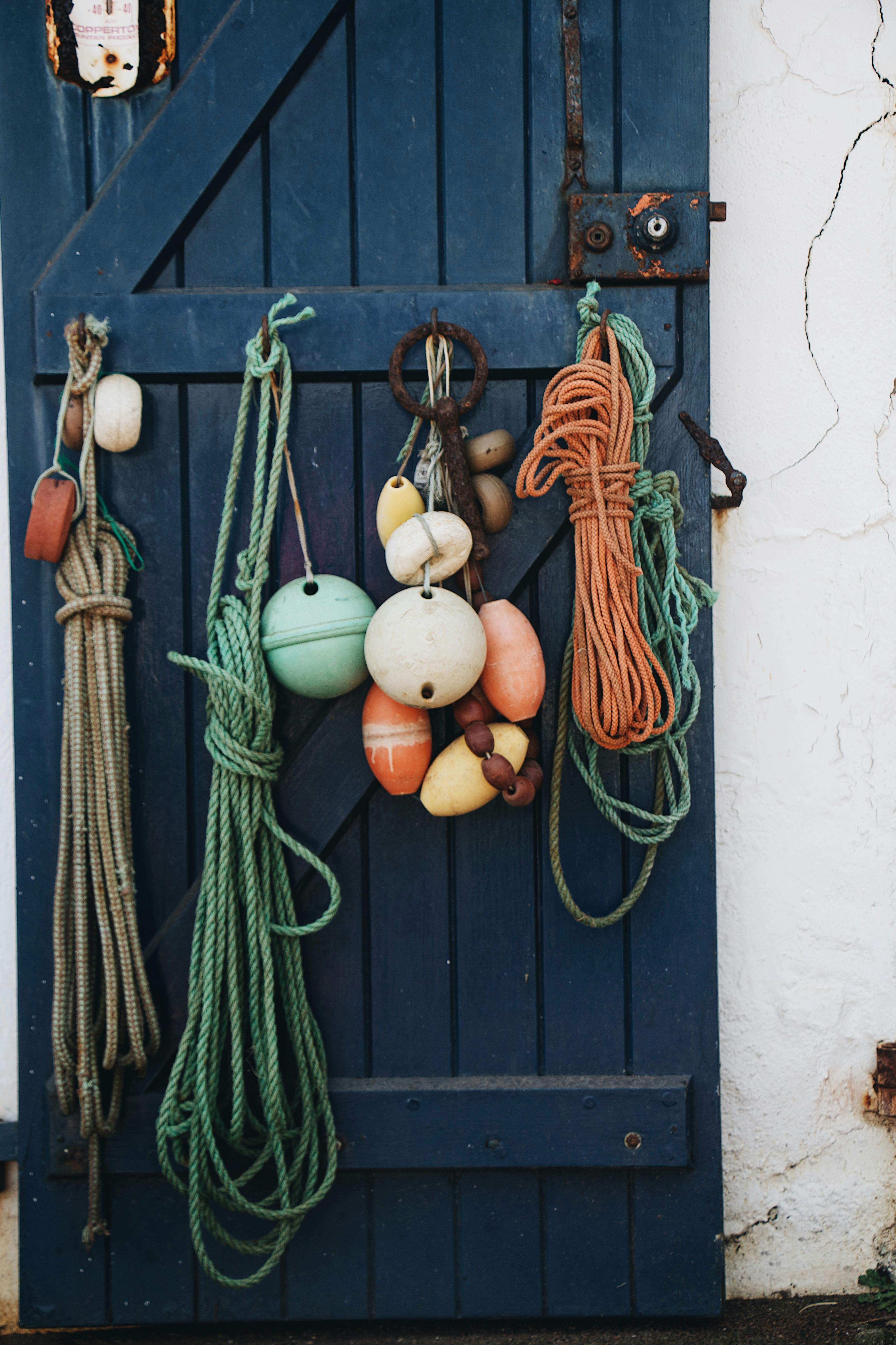 Rope Knots and Buoys Hanging from Blue Wooden Doors · Free Stock Photo