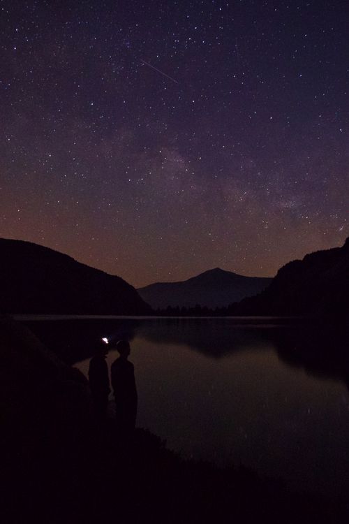 Silhouettes under a starry sky beside a lake — Maël BALLAND on Pexels