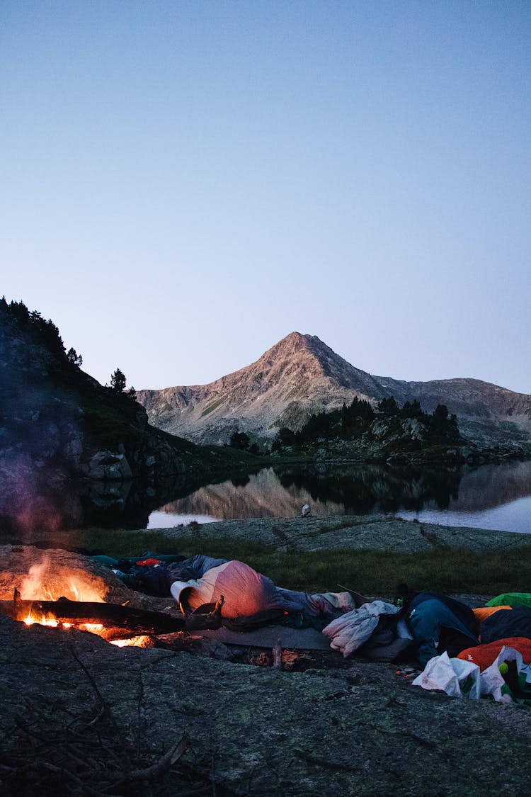 Camping With Tents Around Campfire With Mountain Peak In Background