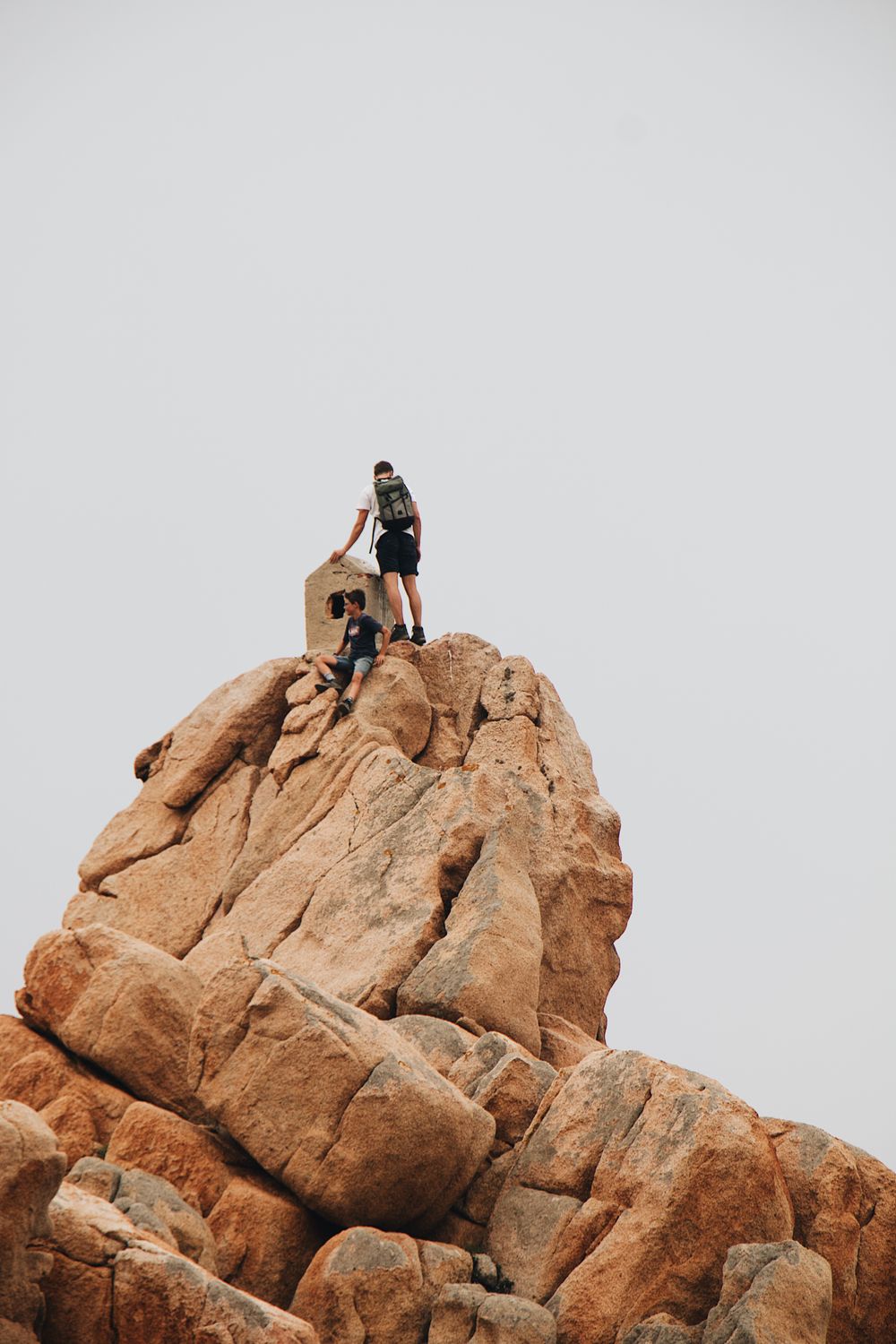 Two climbers ascending a rugged rock formation on an outdoor adventure approach Two climbers ascending a rugged rock formation on an outdoor adventure approach