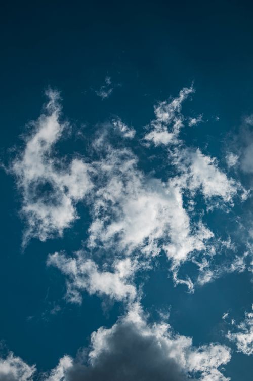 Free Dramatic cloud formations against a clear blue sky, creating a serene atmospheric view. Stock Photo