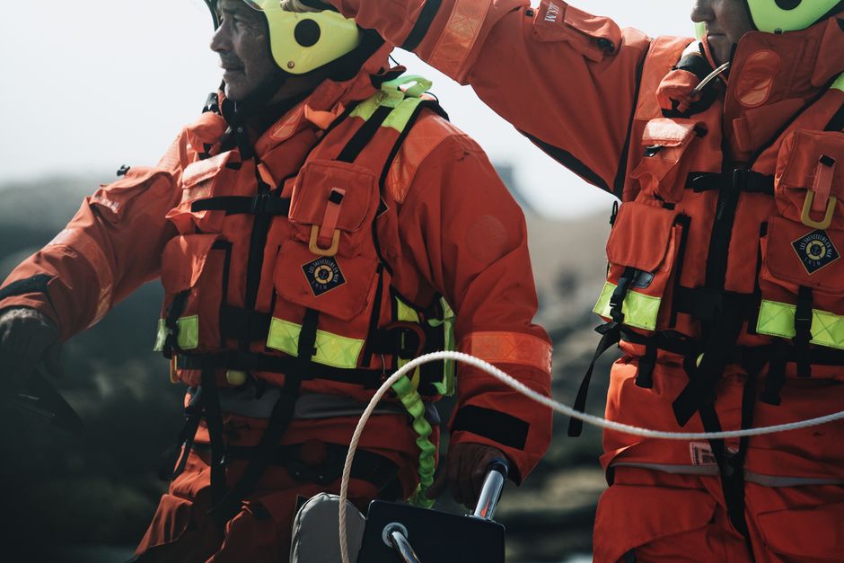 Dedicated rescue team members in high visibility gear conducting an outdoor rescue operation.