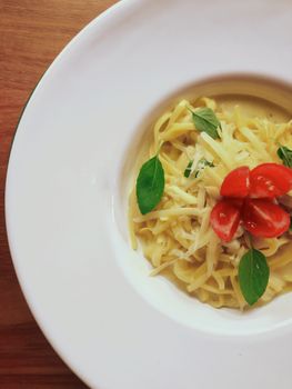 Delicious pasta served with cherry tomatoes and cheese, perfect for food photography enthusiasts.
