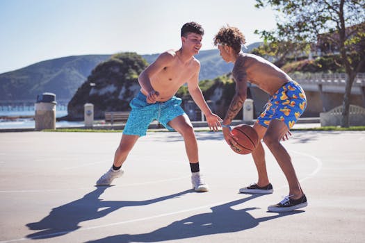 Two young men enjoying a competitive basketball game on a sunny day at Avila Beach, California.