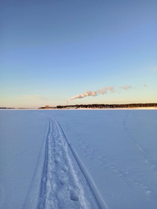 Tracks in a Snow with Smoke over Horizon